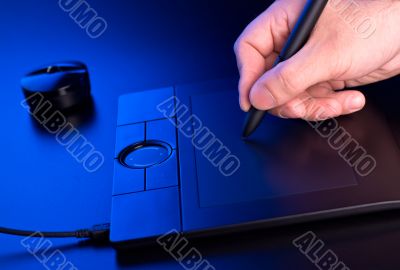 man`s hand draws on graphic tablet