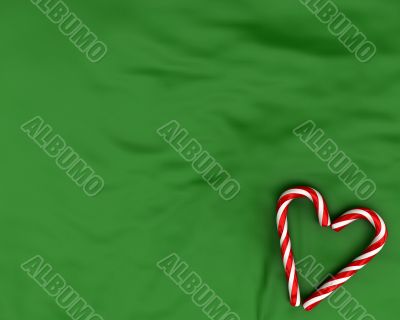 Heart made from christmas candies on green background