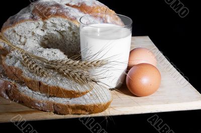 Glass of milk, wheat, eggs and bread