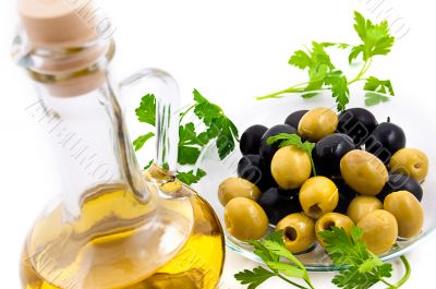 Olives and oil jug with greens