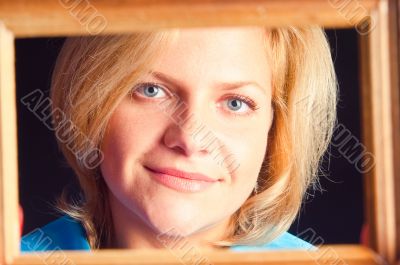 Portrait of the girl in a wooden frame 