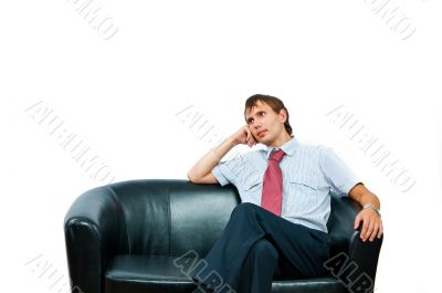 The businessman sits on a sofa 