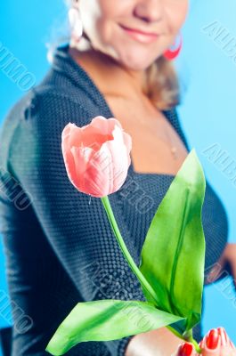The girl gives a pink flower