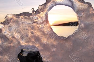 Sunset through ice`s holes in Finland