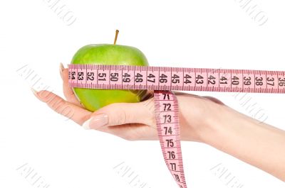 Woman`s hand with apple and measure tape