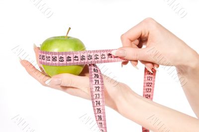 Woman hands measuring green apple