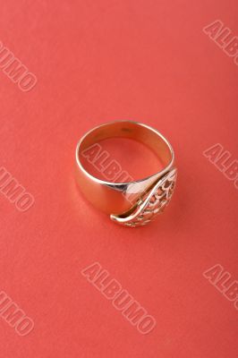 Gold ring on red