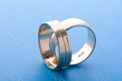 Gold rings on blue background macro