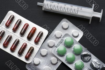 Medical tablet and syringe on black