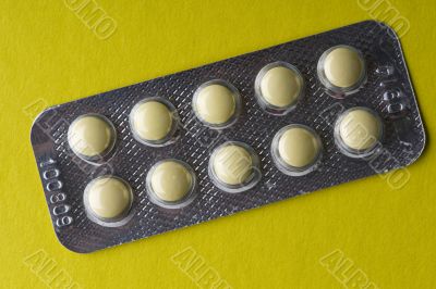 Medical tablet on yellow