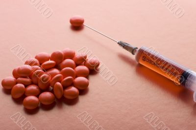 Red Tablet and syringe on red closeup