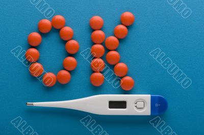 Tablets and thermometer close up