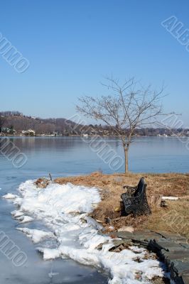 Old empty bench on a frozen lake