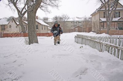 Young boy running home in the snow