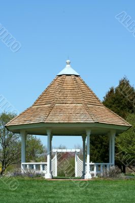 White gazebo in a park with blue sky