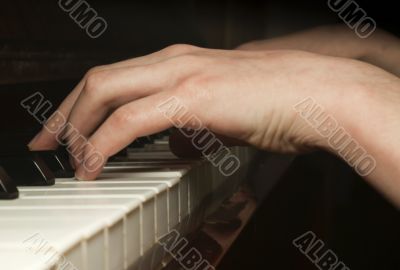 Child`s hand playing on piano keyboard
