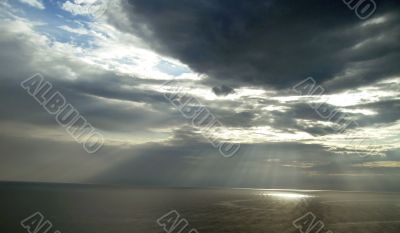 Sun ray flow through the clouds over sea