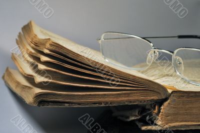 sheets of an old book with glasses