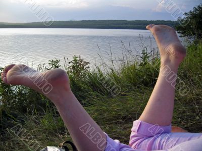 Woman legs and the lake