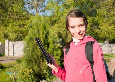 Teen girl with e-book reader outdoors