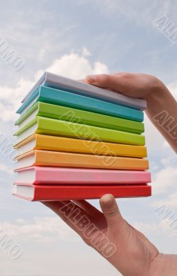 Hands holding color hard cover books