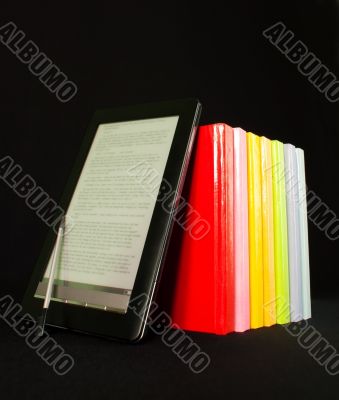 Row of books and electronic book reader