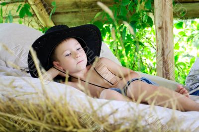 boy in a cowboy hat is in the hayloft