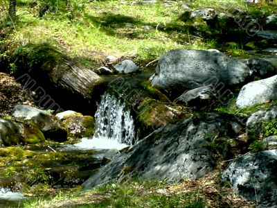 Wild creek amongst stone with moss