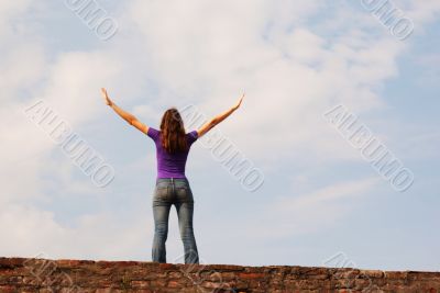 Young woman staying with raised hands