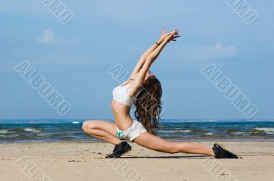 Young woman making exercise on the beach.