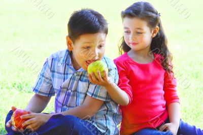 The boy with the girl play sitting on a grass