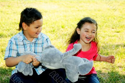 The boy with the girl play sitting on a grass