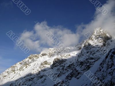 Mountain under the blue sky and the clouds