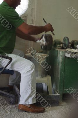 Craftsman using grinder in workshop