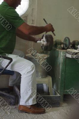 Craftsman using grinder in workshop