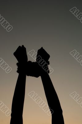 Hands tied up with rope against dark sky