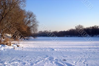 The frozen river under snow