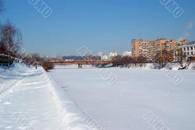The frozen river under snow
