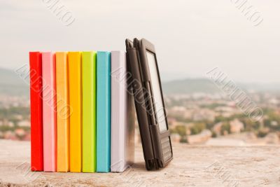 Row of colorful books with e-book reader