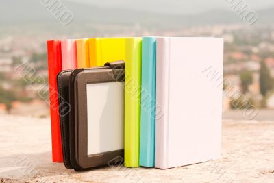 Row of colorful books with e-book reader