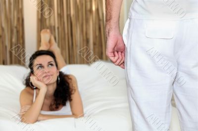 Woman lying on her bed looking up at a man
