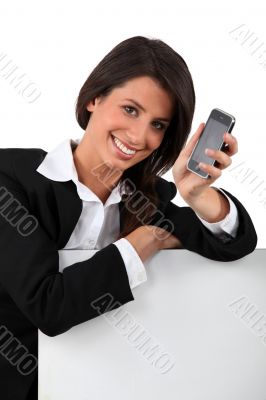 Young woman smiling  holding mobile telephone