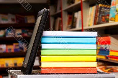 Stack of colorful books with e-book reader
