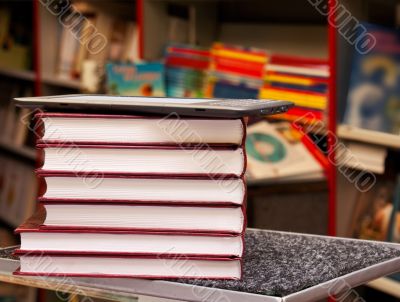 Stack of colorful books with electronic book reader