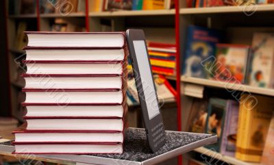 Stack of colorful books with e-book reader