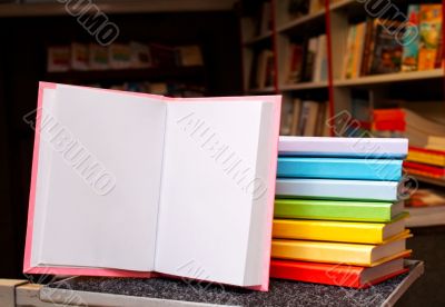 Open book with a stack of colorful books