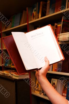 Hand holding the open Bible