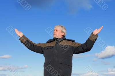 Middle-aged man on blue sky of the background.