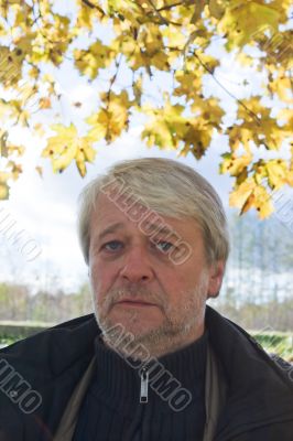 Portrait of middle-aged man in autumn day.