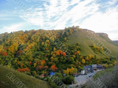 Golden autumn, blue sky and caucasus mountains